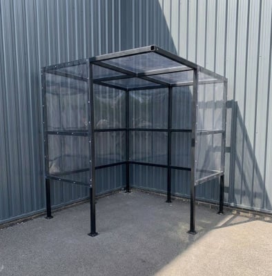 A black powder coated shelter for a corner of a premises