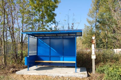 Anti-vandal Ruby bus shelter with steel frame and walls, with seating and bin.