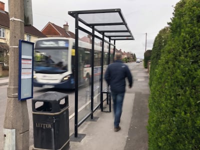 Cantilever bus shelter with steel frame and polycarbonate panels.